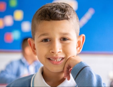 Boy in class smiling at camera