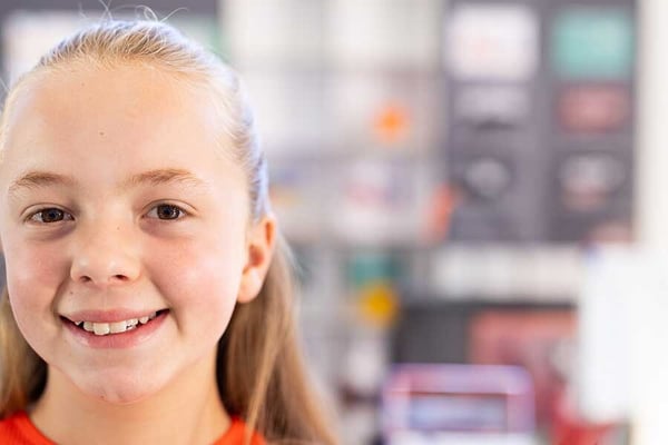 Student smiling in a classroom.