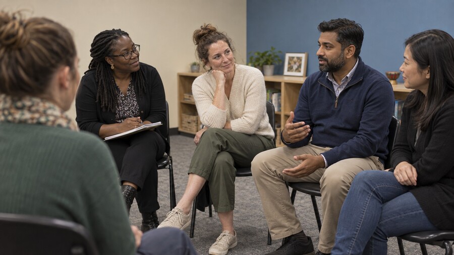 Adults seated in a circle for a group discussion.