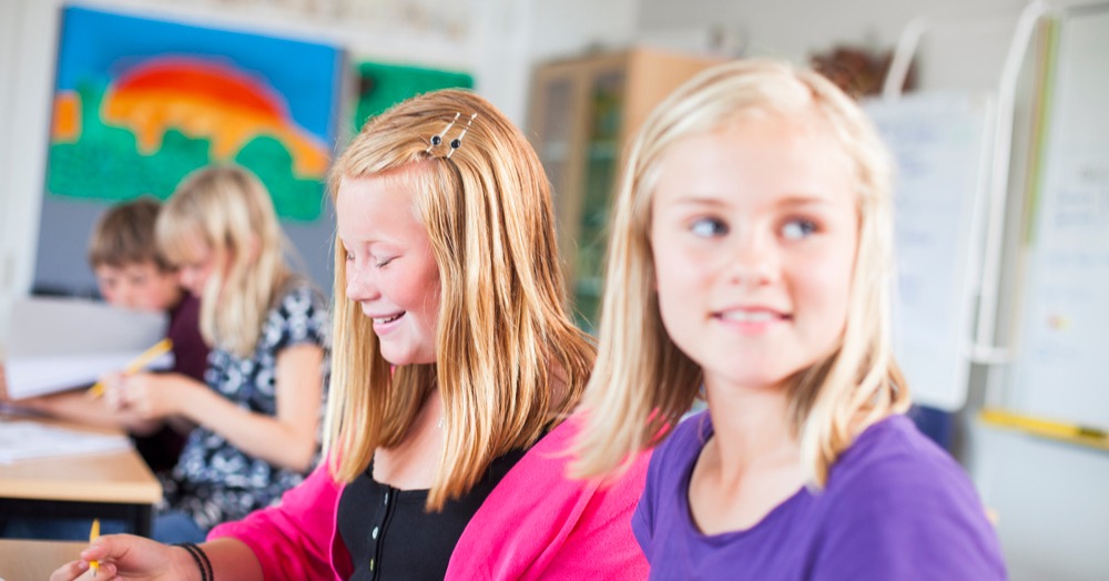Girls sitting next to each other in a classroom