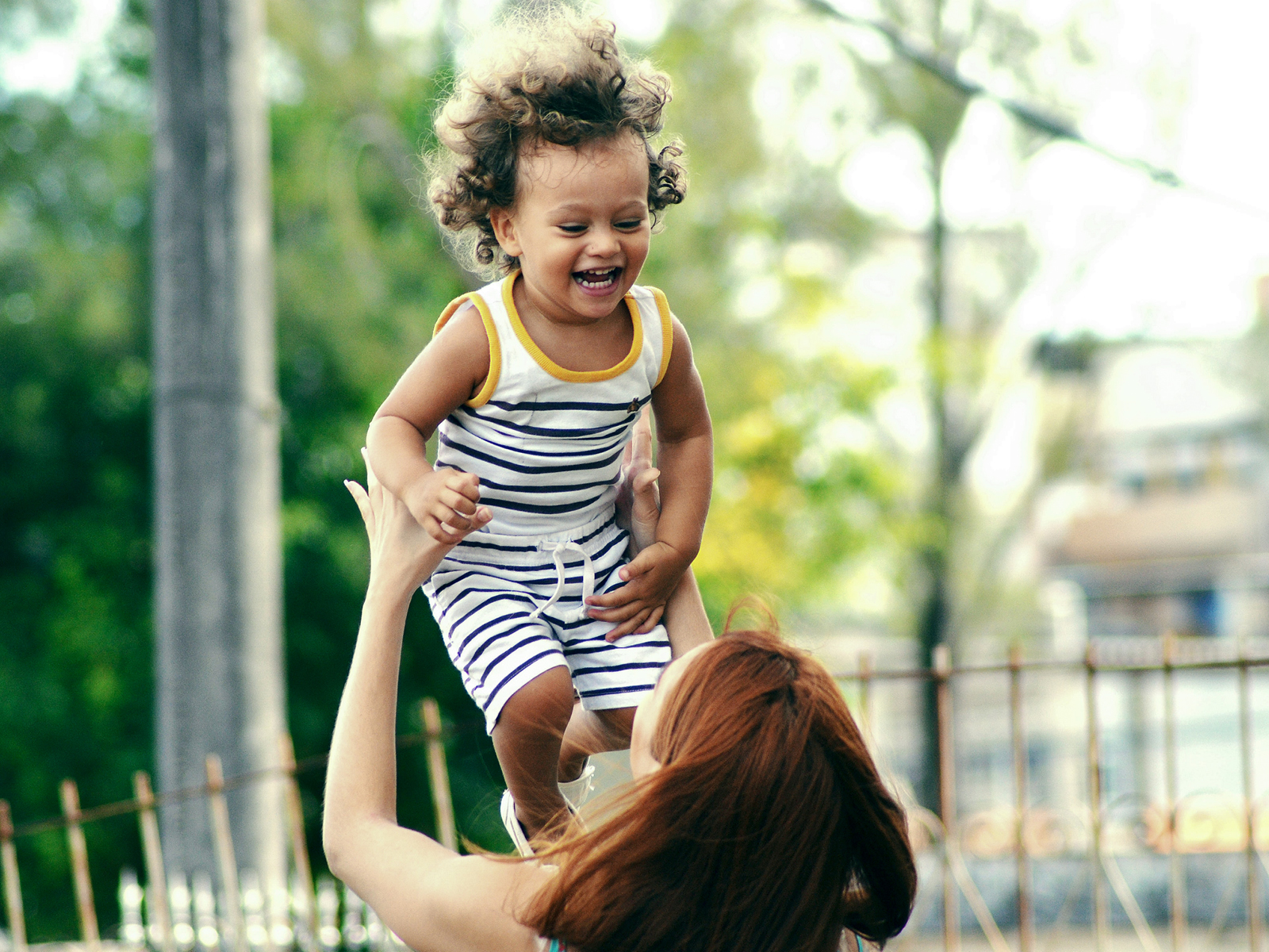 A mother tossing and catching her laughing child